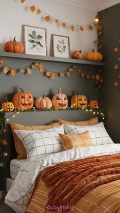 a bedroom decorated for halloween with pumpkins on the headboard and lights hanging above