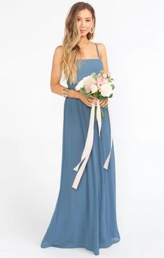 a woman in a blue dress holding a bouquet