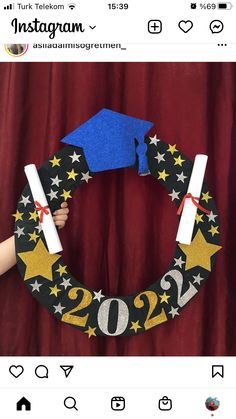 someone is holding a graduation wreath made out of construction paper and some glue on it