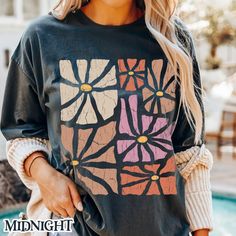 Embrace the beauty of nature with this vintage boho wildflowers tee, featuring a stunning retro flower design that captures the essence of a blooming garden. Perfect for free spirits and nature lovers, this shirt combines a 70s-inspired aesthetic with modern boho vibes. Whether you 're wandering through a garden or relaxing with friends, this tee adds a touch of floral charm to any outfit. Made for those who appreciate the simple beauty of nature, it's an ideal choice for casual outings, festiva Artsy Spring Tops With Graphic Print, Artsy Spring Top With Graphic Print, Artsy Graphic Print Tops For Spring, Spring Hippie Tops With Retro Print, Hippie Graphic Print Top For Fall, Vintage Graphic Print Top For Spring, Vintage Print Hippie Tops For Summer, Bohemian Multicolor Top With Screen Print, Hippie Style Graphic Print Spring Tops