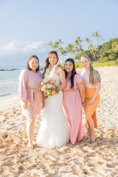 four bridesmaids pose for a photo on the beach