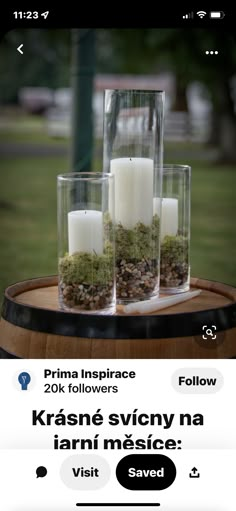 candles and moss are placed in glass vases on a barrel