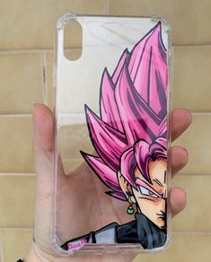 a person holding up a phone case with a dragon on it's back and pink hair