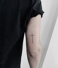 a man with a cross tattoo on his arm