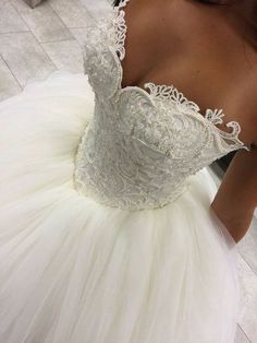 the back of a woman's wedding dress with lace on top and tulle skirt