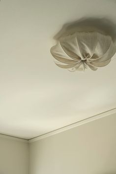 an empty room with white walls and a ceiling fan hanging from the ceiling above it