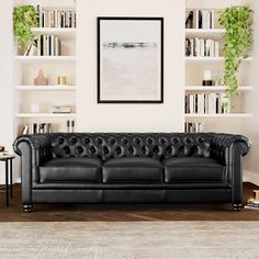 a black leather couch sitting in front of a bookshelf