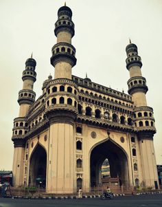 an old building with two towers on the top and one at the bottom that has a motorcycle parked in front of it