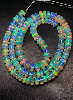 18 Inch Rare Natural Welo Ethiopian Opal Beads, Smooth Roundel Beads Strands, 6 To 8 MM Approx 104 Ct, Opal Plain Beads, Making Necklace.  Product Detail :-- Gemstone  :-   Natural Ethiopian Opal Shape  :-   Roundel   Size  :-   6 To 8 MM Approx Weight  :-    104 Ct   Quantity  :-  1 We have lots of designer fashion jewelry. We are manufacturer, wholesaler and exporter of gemstones and handmade jewelry. We always try fulfilled our customers requirements as per their sanctification. Because We wants to long term Business with you. For More Products, Click on below Link https://www.etsy.com/in-en/shop/firegemsandjewellery?ref=seller-platform-mcnav Thank You for Visit Our Shop Fire Gemstone Jewelry If you require additional quantities of this (or any other item), please ask! All of our prices Rainbow Spacer Beads, Rainbow Polished Beads For Jewelry Making, Iridescent Colorful Beaded Necklace, Handmade Iridescent Beaded Necklaces With Round Beads, Iridescent Round Beads For Jewelry Making, Beads Making, Waist Beads, Opal Beads, Designer Fashion Jewelry