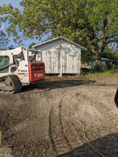 a small tractor is parked in the dirt