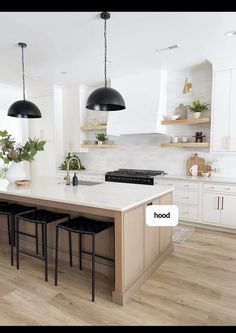 the kitchen is clean and ready to be used for cooking or baking, with white cabinets and black pendant lights