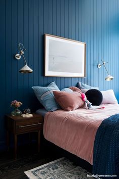 a bedroom with blue walls and pink bedding