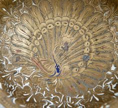 an ornate gold plate with a peacock on it