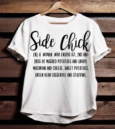 a white t - shirt with the words side chick on it hanging up against a wooden wall