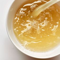 a white bowl filled with liquid and a spoon