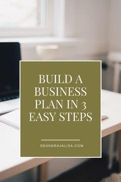 a laptop computer sitting on top of a white desk next to a window with the words build a business plan in 3 easy steps