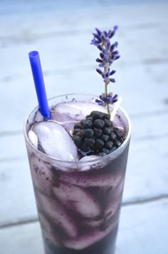 a purple drink with ice, blackberries and lavender sprig on the side