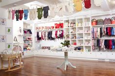 a baby store with lots of clothes hanging from the ceiling and shelves filled with clothing