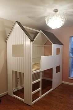 there is a bunk bed in the corner of this room with a chandelier hanging from the ceiling