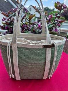 a purse sitting on top of a pink table