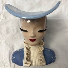 a ceramic figurine wearing a blue hat