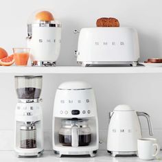 there are many appliances on the shelves in this kitchen, including an espresso machine and toaster