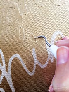 someone is using scissors to paint the letters on fabric