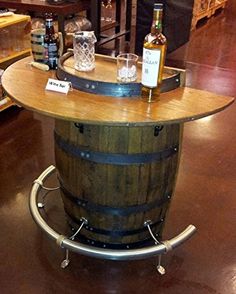 a wooden barrel sitting on top of a table in a room filled with bottles and glasses