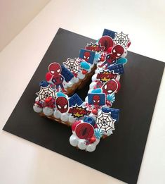 a cake shaped like the letter e with spiderman decorations