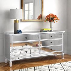 a white dresser with drawers and a mirror on the wall