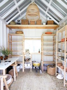 a room filled with lots of wooden shelves and furniture next to a white wall covered in wicker baskets