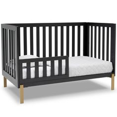 a black crib with white sheets on it