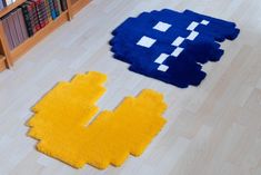 two rugs on the floor in front of a book shelf and bookshelf