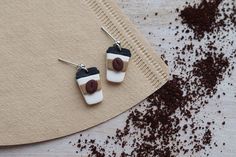 two coffee mugs are sitting on top of a piece of brown paper next to chocolate chips