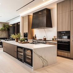 a modern kitchen with marble counter tops and stainless steel oven hoods, built - in wine refrigerator