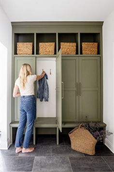 a woman standing in front of a green cabinet