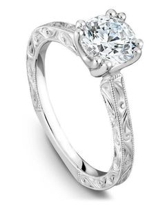 a diamond engagement ring with filigrees on the sides and an engraved band