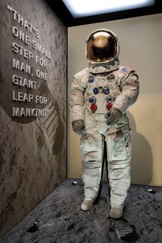 an astronaut's suit is displayed in front of a wall that says, that's one small step for man, one giant leap for leap for making