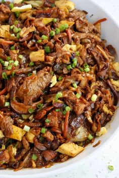 a white bowl filled with meat and vegetables