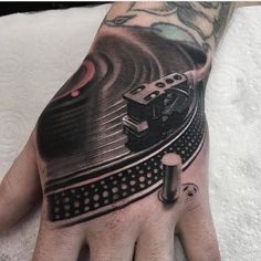 a man's hand with a dj record player tattoo on it