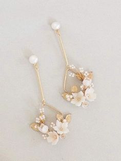 two pairs of earrings with flowers and pearls on the ear wires, one is gold