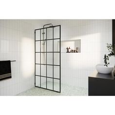 a bathroom with white tile and black accents