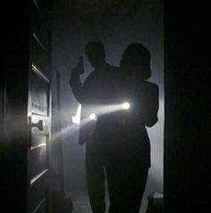 two people are standing in the dark holding flashlights