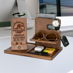 an assortment of personal items are arranged on a desk top with a cell phone and sunglasses