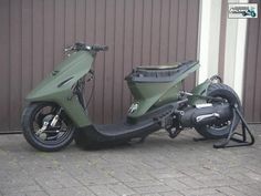 a green scooter parked in front of a building