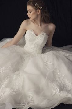 a woman in a wedding dress sitting on the floor