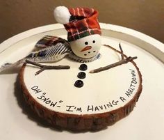 a small snowman is sitting on top of a wooden slice that says, i'm having a merry christmas