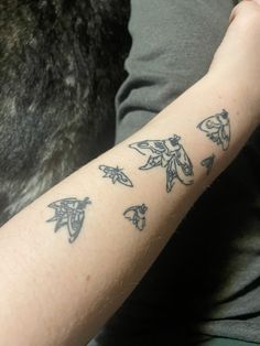 a person with a tattoo on their arm that has birds flying in the sky above them