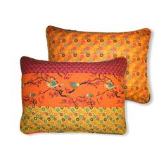 two orange pillows with birds on them, one has an orange background and the other is yellow