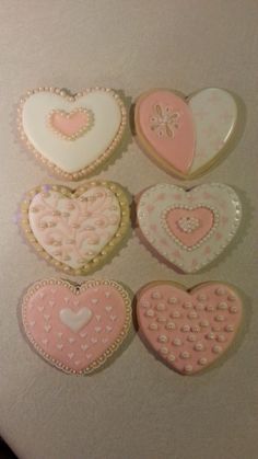 four decorated cookies in the shape of hearts